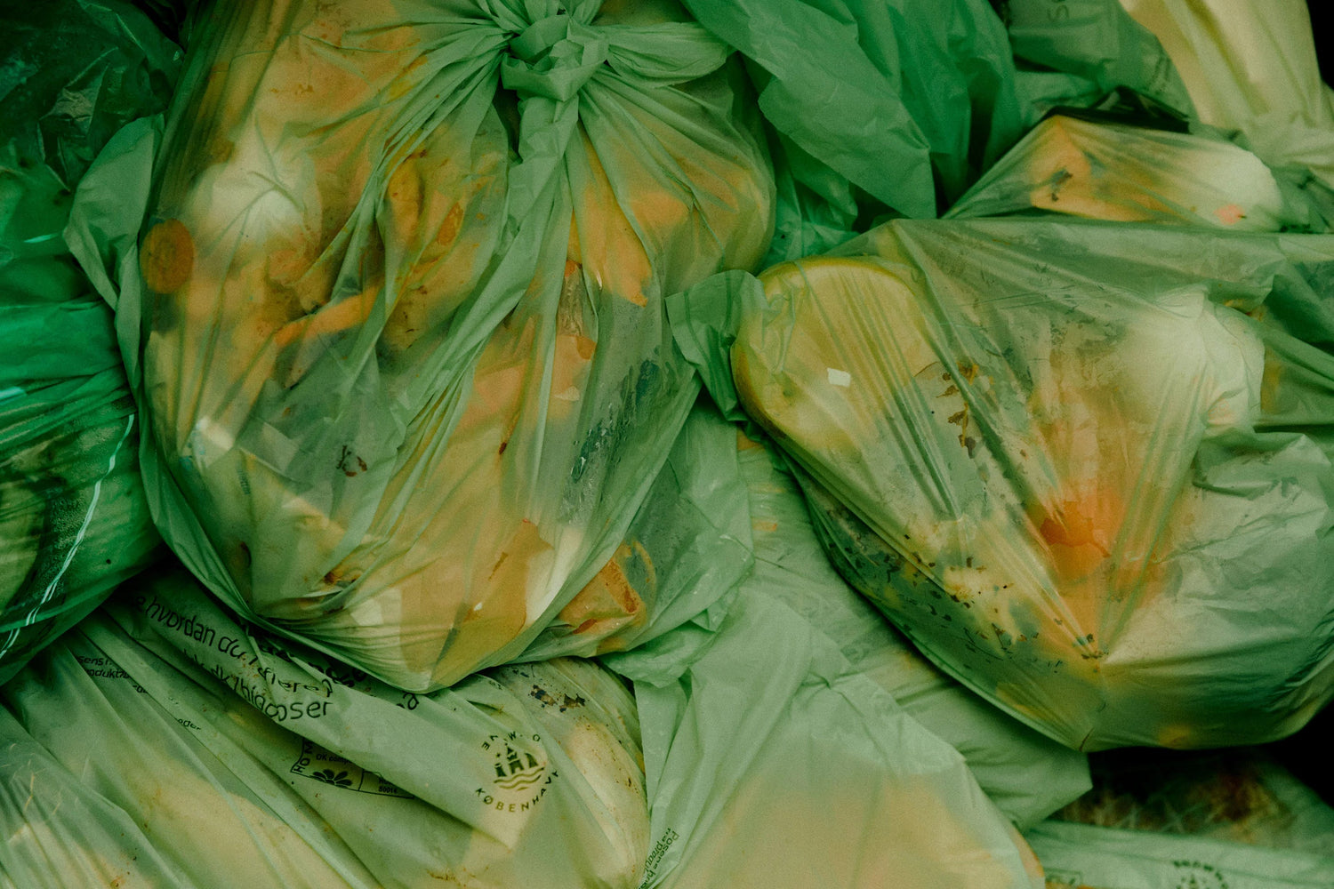Green compostable bags containing yellow vegetables