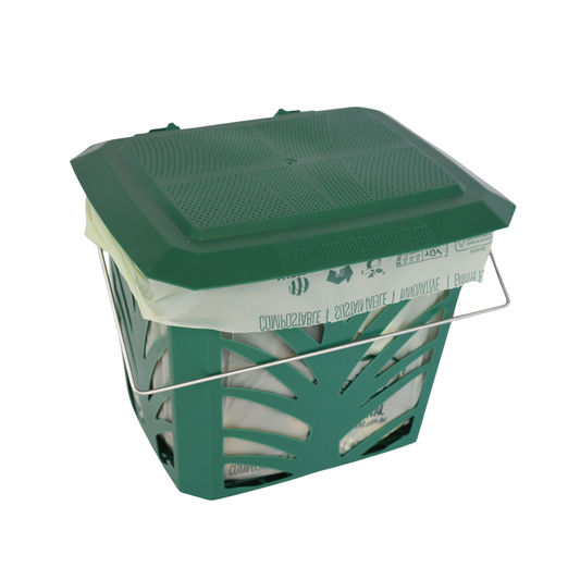 Green caddy compost bin with cut out for ventilation and compostable bag inside on a white background