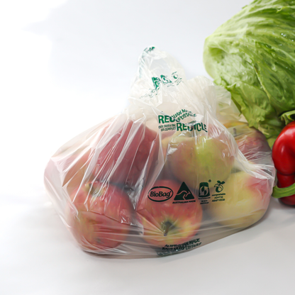 Compostable food produce bag filled with apples with a visible Biobag logo, surrounded by a head of lettuce and a tomato on a white background.