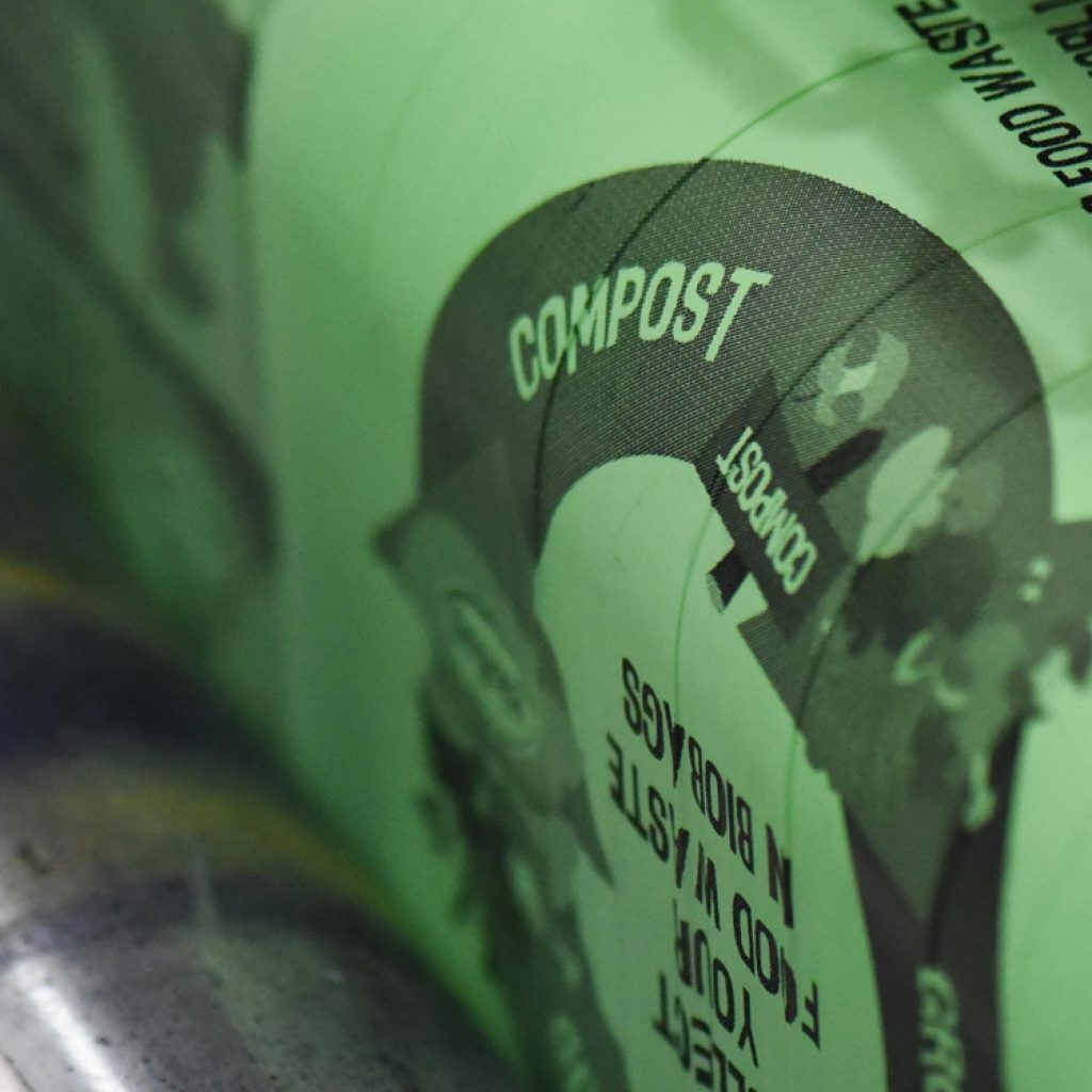 Green compostable bag with compost text on a roll