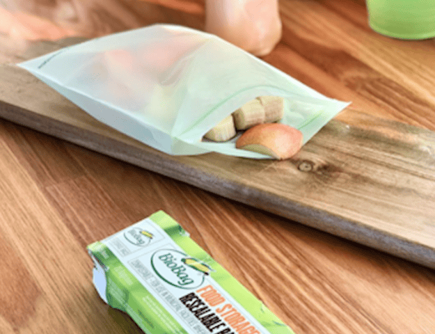 Biobag resealable food package filled with fruit on a wooden surface.